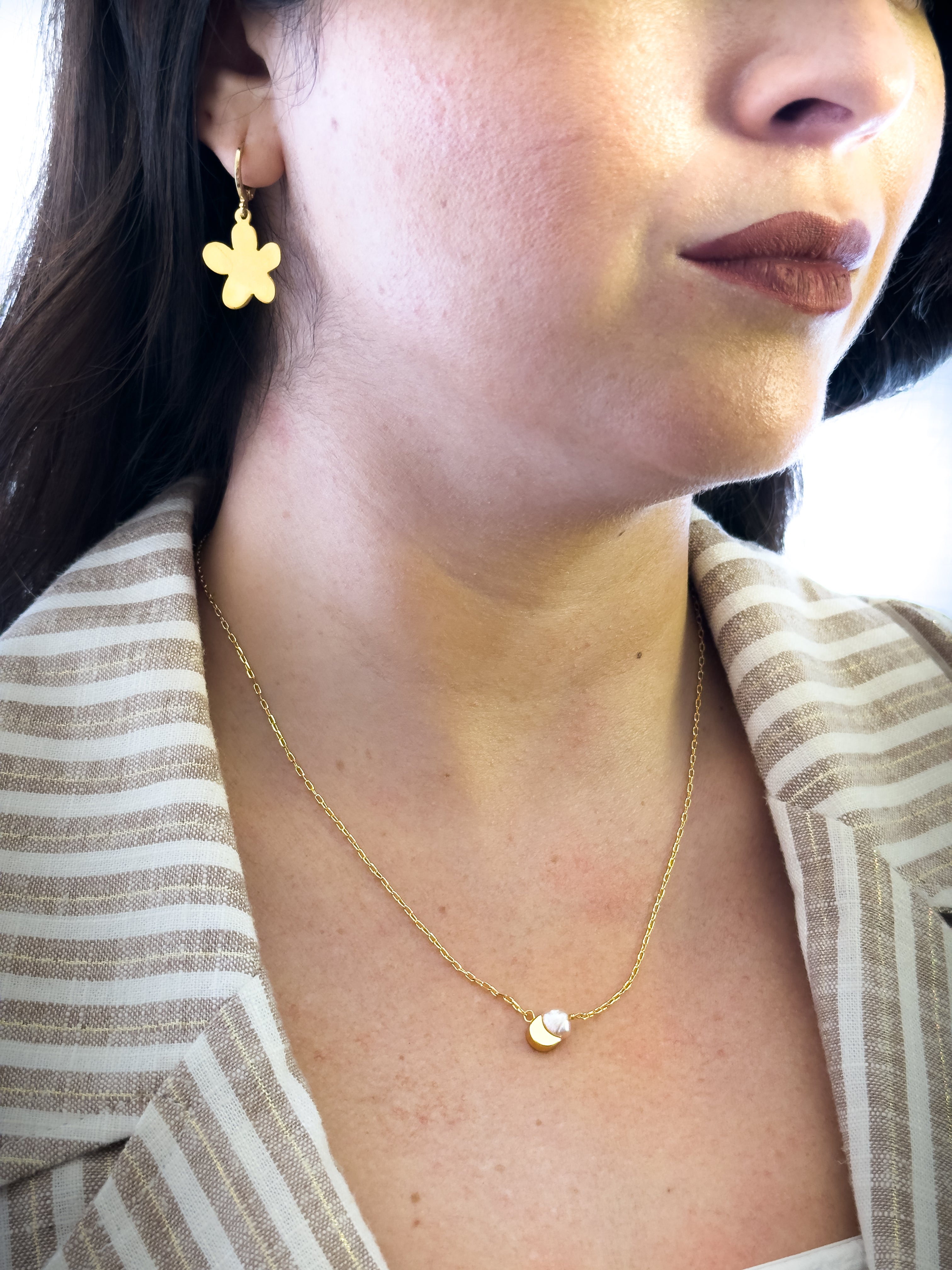 Descubre el collar con perla cultivada natural y dije bañado en oro de MAVIS. Disponible en corazón, estrella, luna, corona y trébol. Una joya delicada con significado para usar todos los días.