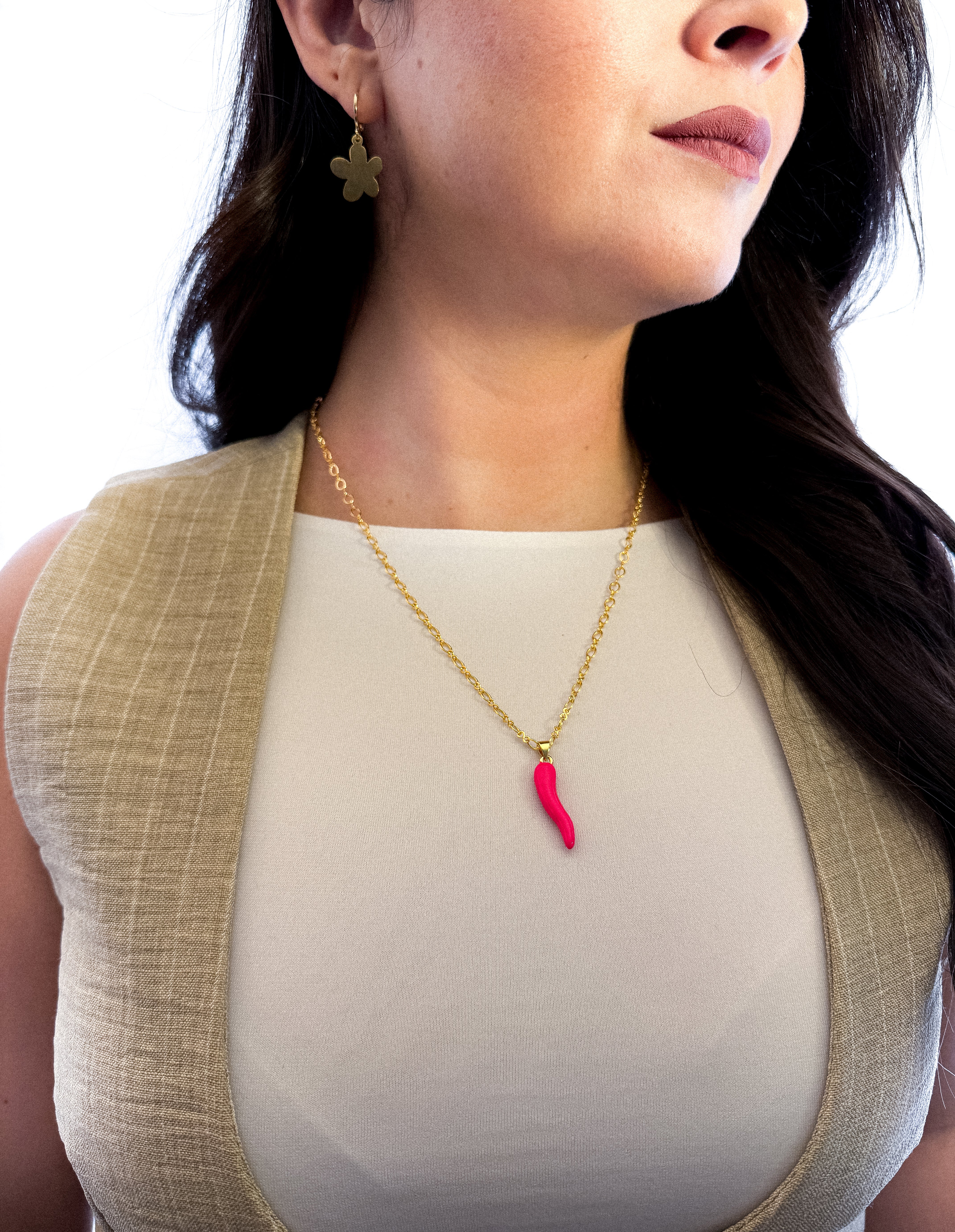 Modelo usando collar Cornicello fuccia de MAVIS con cadena dorada y look minimalista.