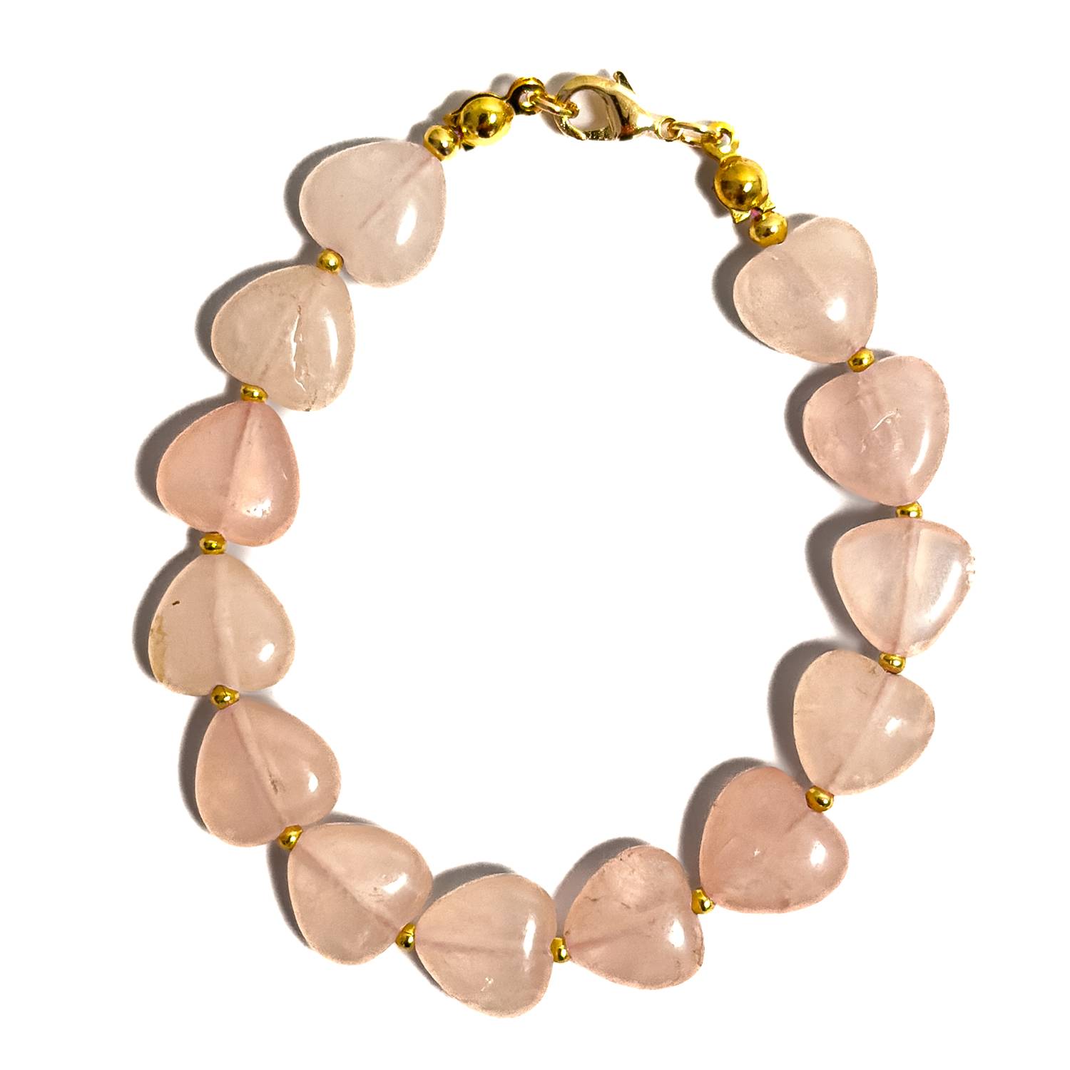 Pulsera artesanal MAVIS elaborada con corazones de Cuarzo Rosa natural pulido, separadores dorados y broche con baño dorado.