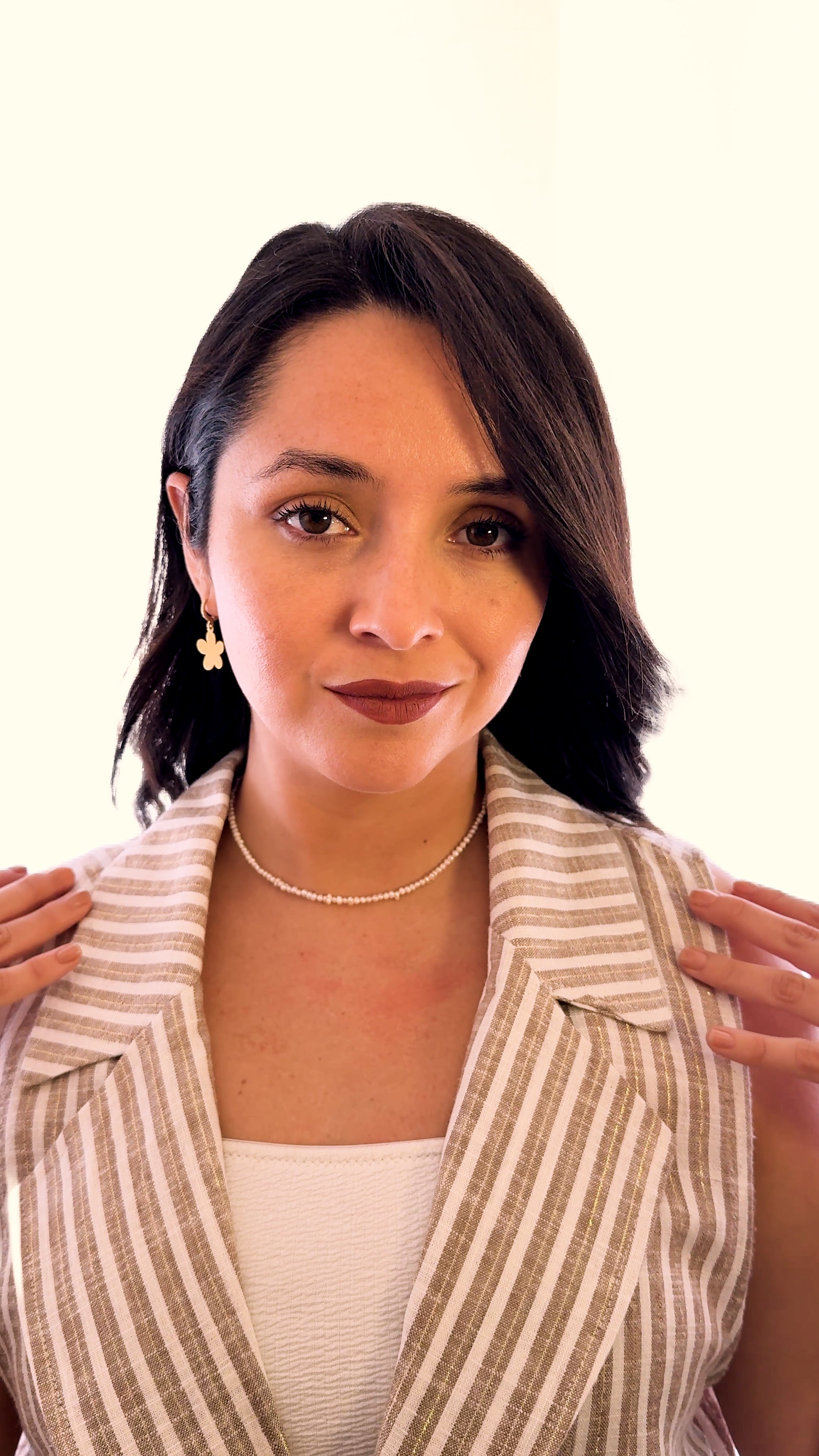 Modelo usando collar corto de micro perlas cultivadas de MAVIS con blazer beige y look minimalista.