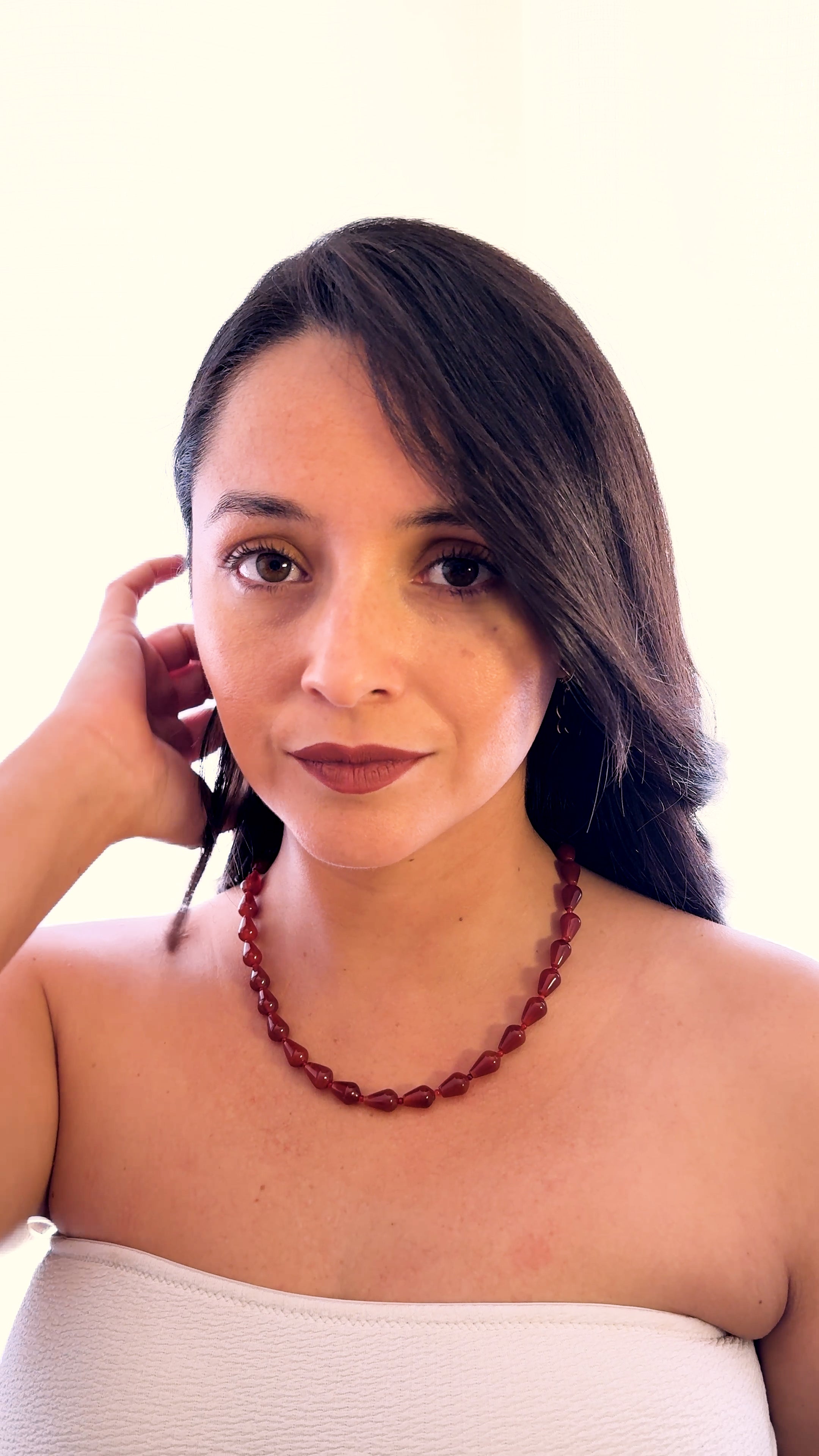 Mujer usando collar de cornalina natural en forma de gota de la marca MAVIS.