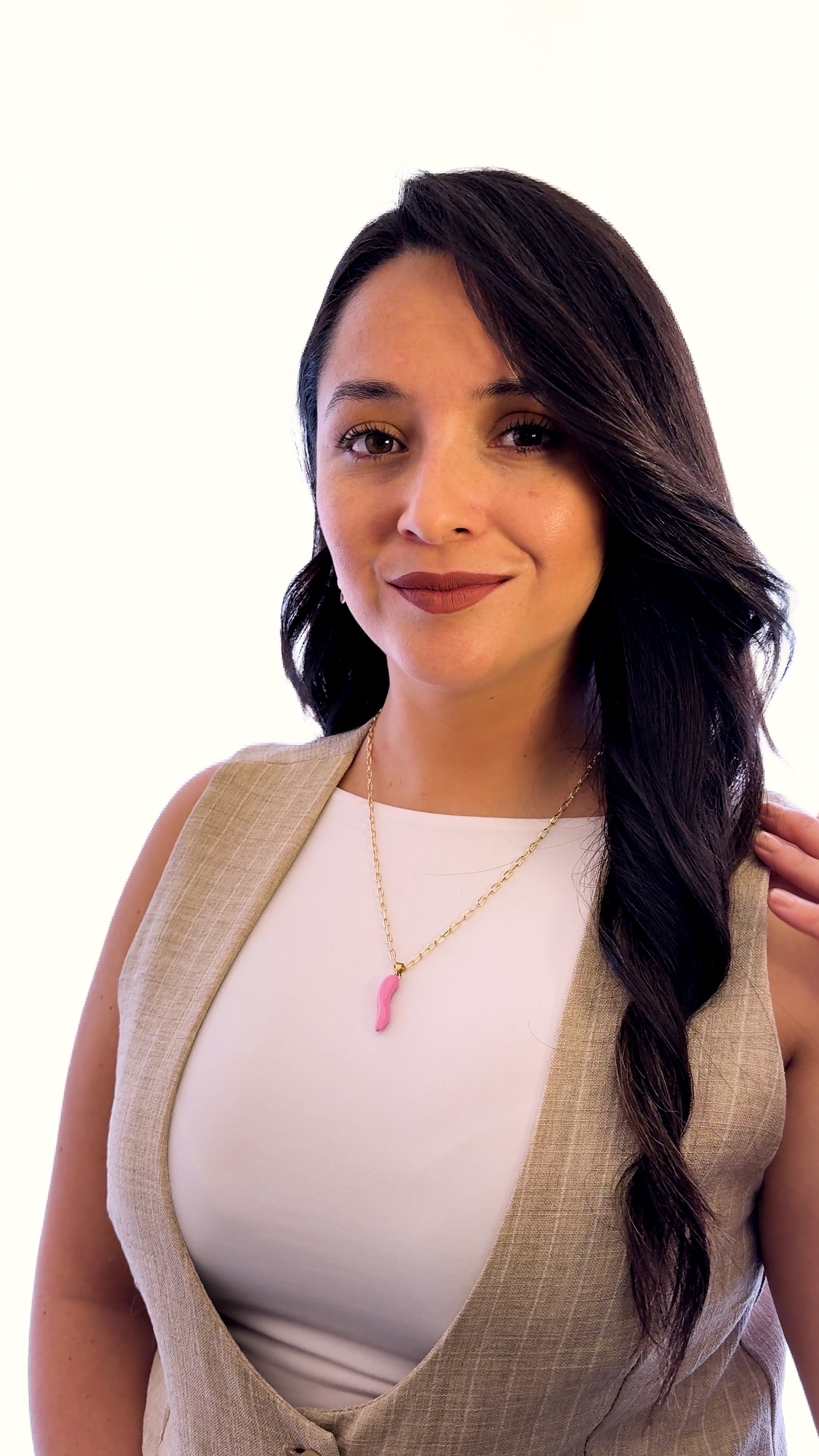 Modelo usando collar Cornicello rosado de MAVIS con cadena dorada y look minimalista.