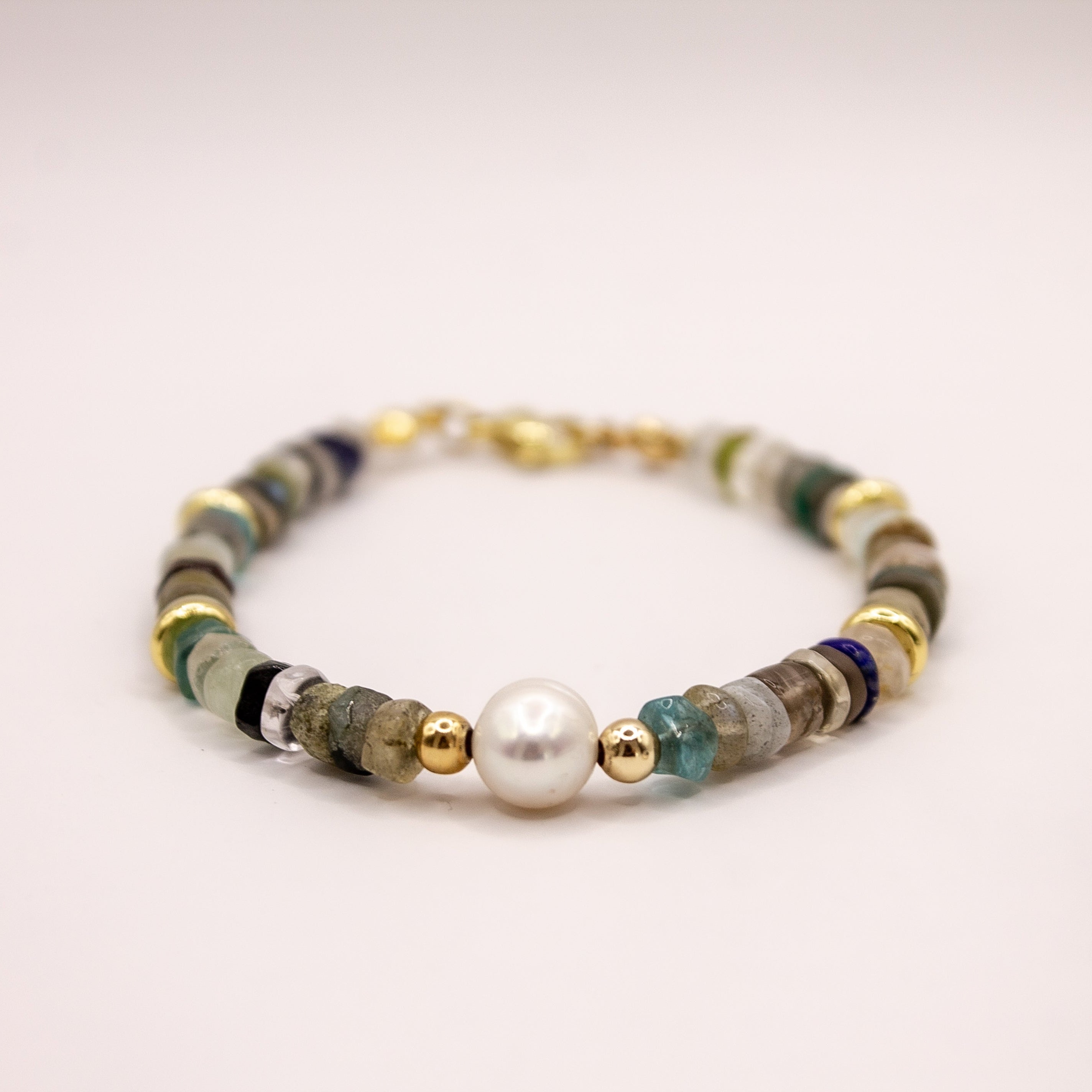 Pulsera artesanal MAVIS elaborada con piedras naturales mixtas, perla de agua dulce, separadores dorados y broche de acero inoxidable.