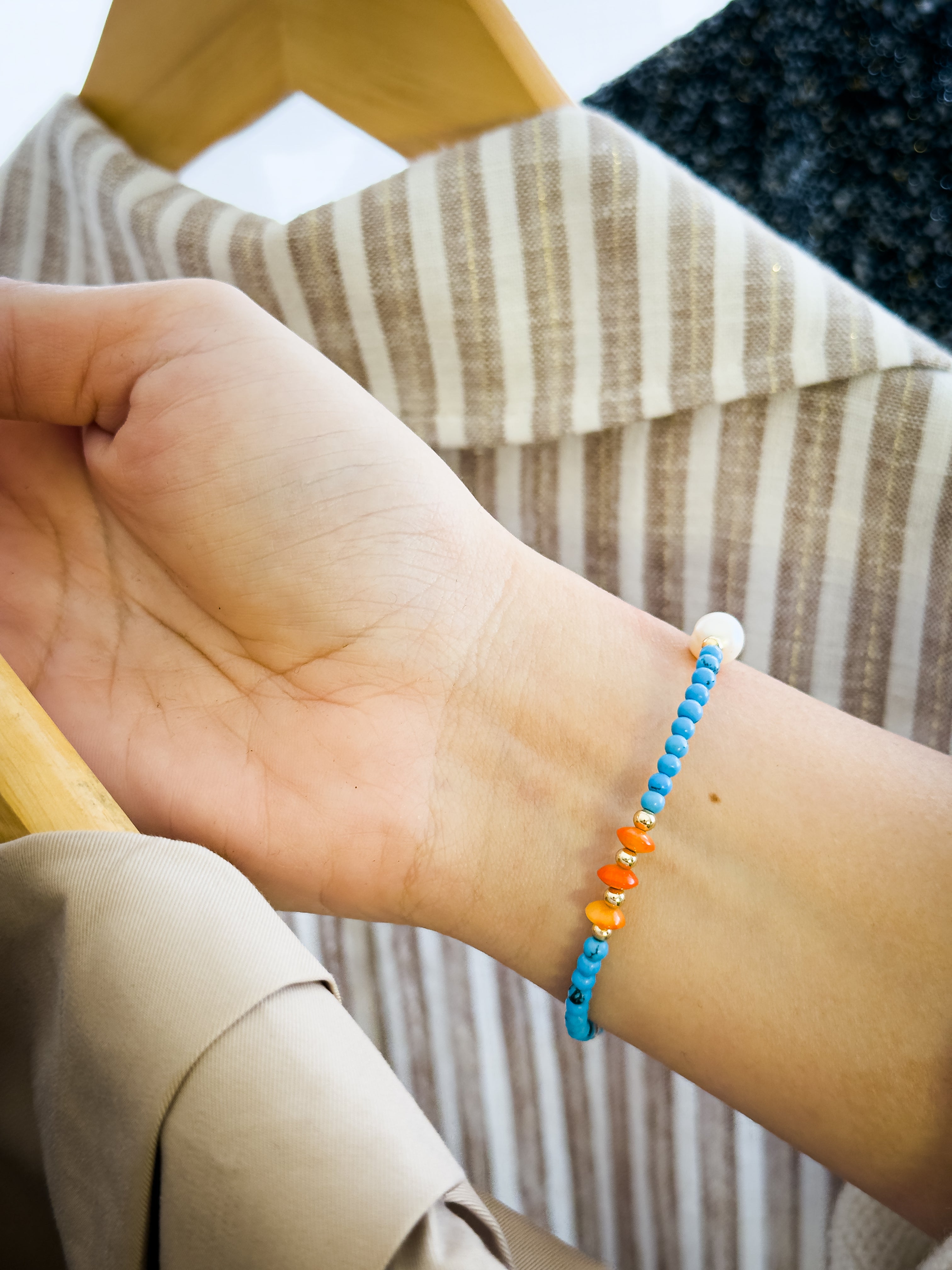 Pulsera de turquesa, coral y perla sobre la muñeca, mostrando un diseño fresco, colorido y elegante para uso diario.