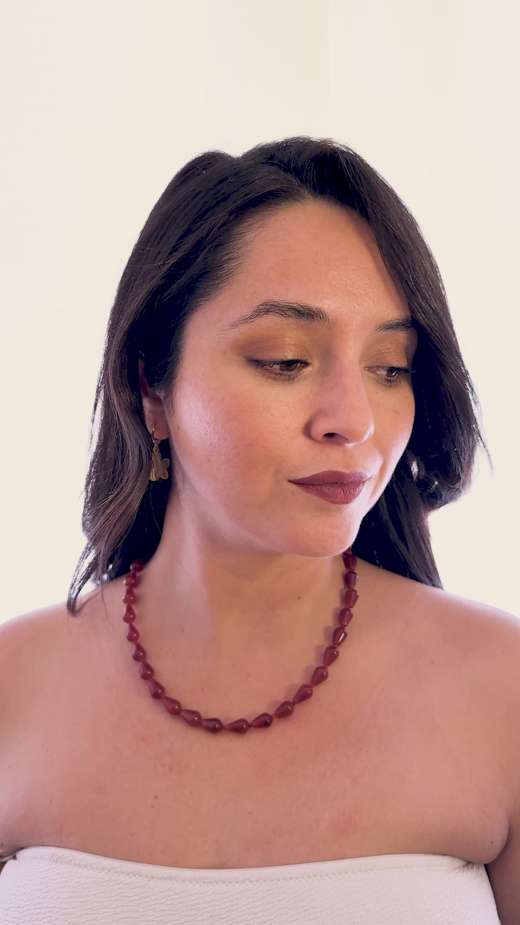 Mujer usando collar de cornalina natural en forma de gota de la marca MAVIS.