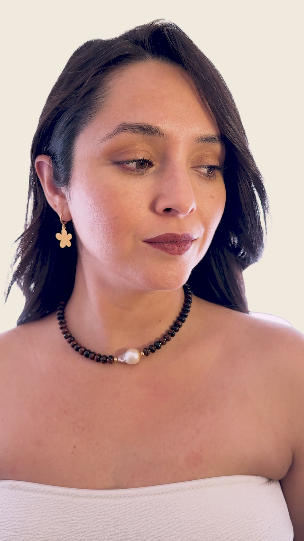 Mujer usando collar de obsidiana caoba con perla barroca de la marca MAVIS.