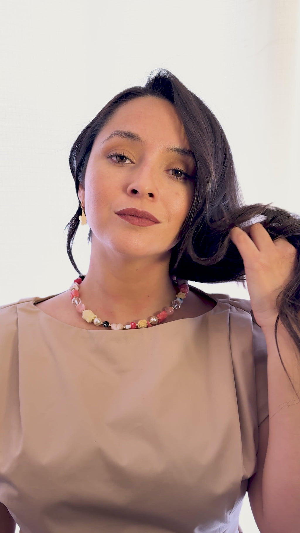 Modelo usando el Collar Fortuna de MAVIS con amuletos de protección, perlas y cristales en un diseño artesanal colorido.